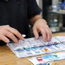 Person carefully testing aquarium water with a kit